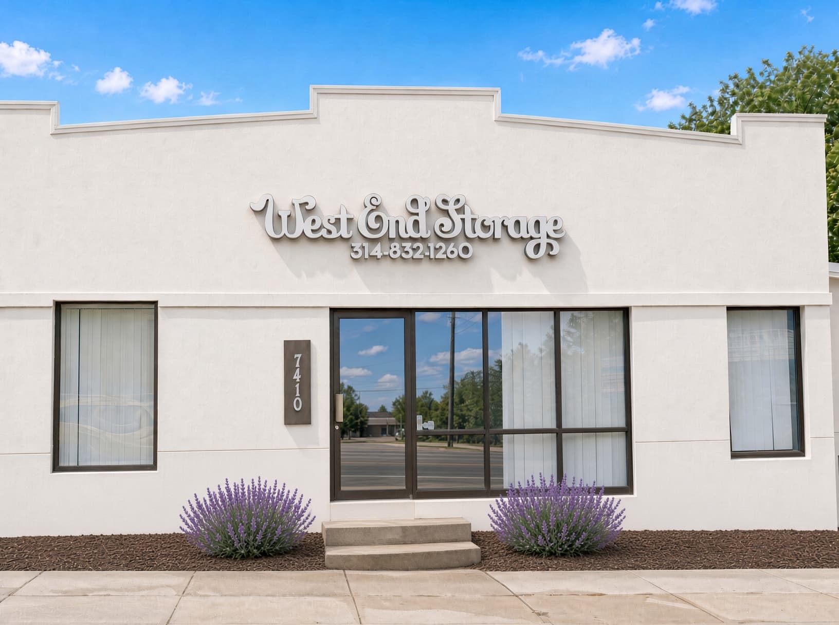 Front of West End Storage at 7410 Eugene Ave, with the script sign above the entrance and lavender beside the steps